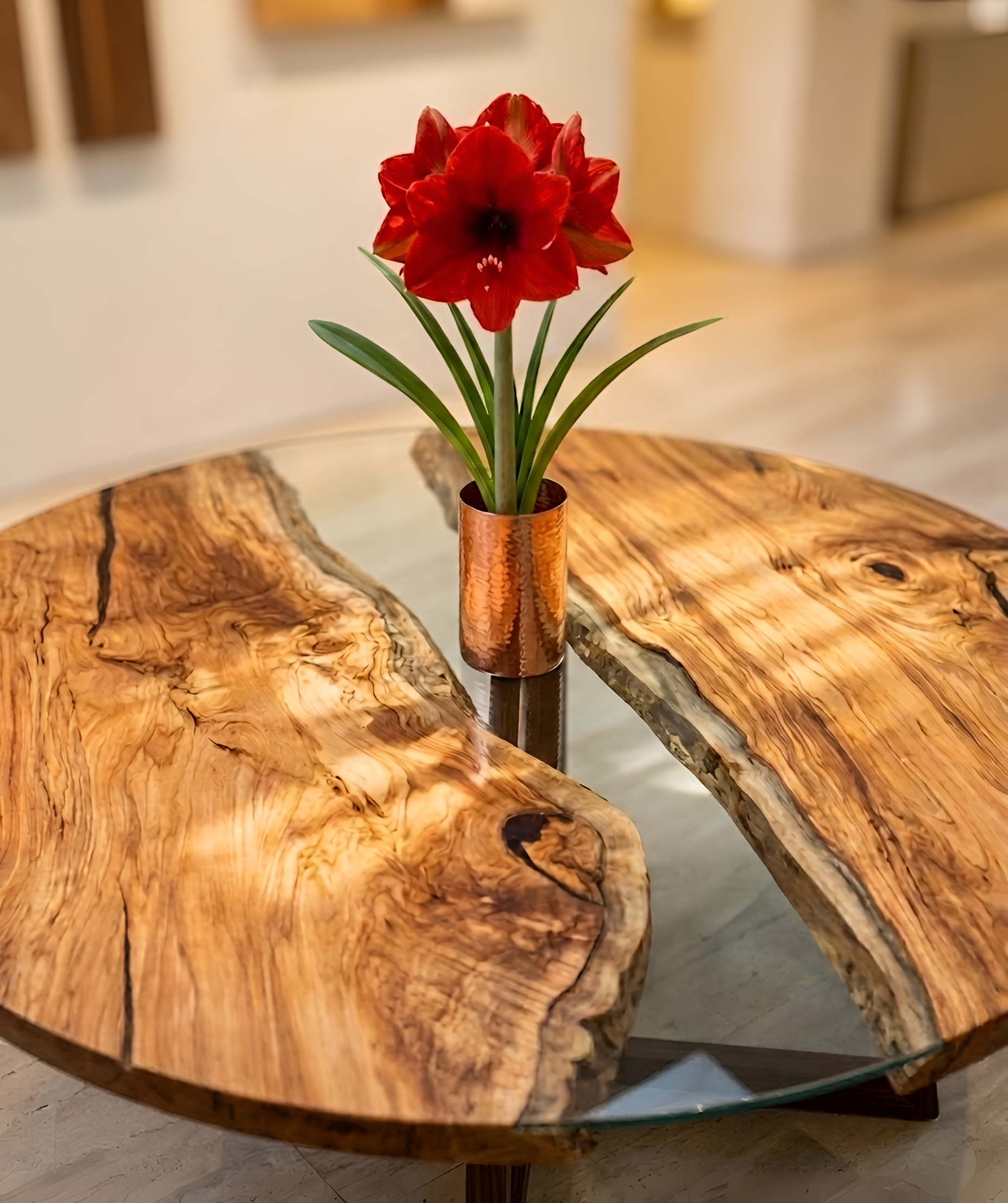 Live-edge walnut and glass table with custom millwork detail and red amaryllis in copper vessel